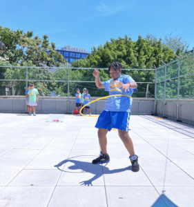Teen boy hula hooping in sports fitness class.